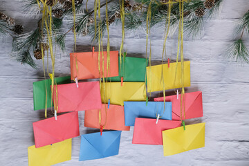 Advent calendar on a background of a brick wall. Multicolored envelopes made by hand.