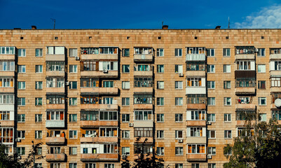 Windows and balconies of the residential building. Old urban obsolete facade of house. The windows of an ordinary soviet building.