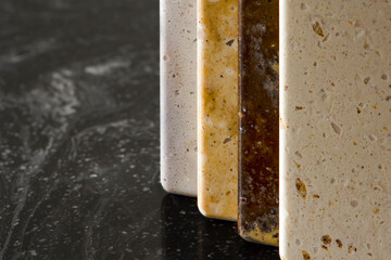 Large selection of stone samples for countertops and floors. Pieces of artificial acrylic stone in a sample box. A set of shades of countertops of different textures