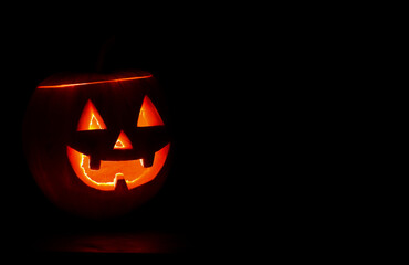 Glowing halloween pumpkin on black background.Trick or treat. Copy space for text