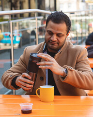 Man using a vaccume carafe outside a train station