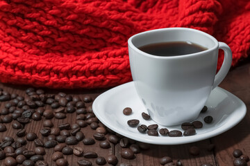 White coffee set on a background of coffee beans and a red knitted scarf