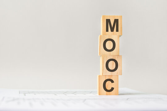word MOOC on wooden blocks, gray background, business concept. business and finance