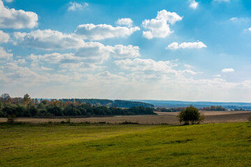 Panorama of a picturesque view of a plowed field and forested areas in the background in the fall in the morning