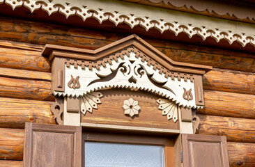 Fototapeta premium Windows of wooden house decorated with wooden carvings