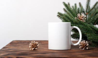Christmas mockup one white empty tea mug on a brown wooden table and branches of a Christmas tree wreath.