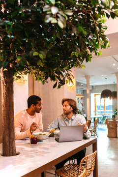 Men sitting in cafe and using laptop