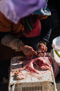 Anonymous female cutting meat at outdoor market