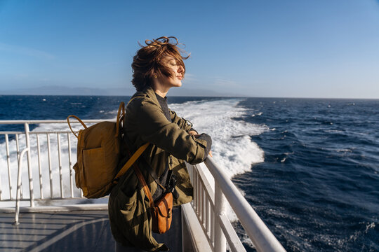 Dreamy female standing on deck in wind
