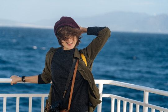 Happy female standing on deck in wind