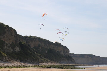 Plein de parapentes survolant la falaise