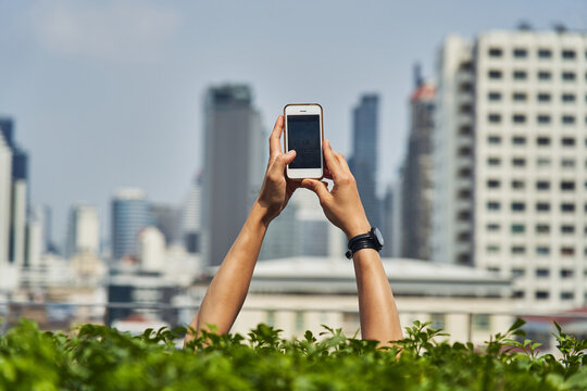 Person taking photo on city landscape on smartphone
