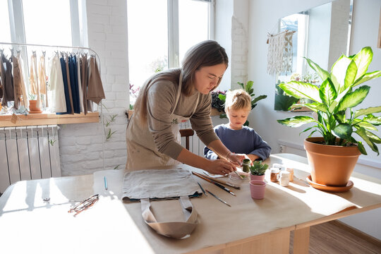 Mother and son crafting cotton bags