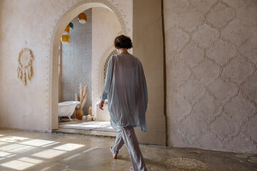 Unrecognizable woman walking towards Arabic bathroom