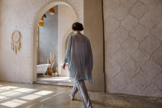 Unrecognizable woman walking towards Arabic bathroom