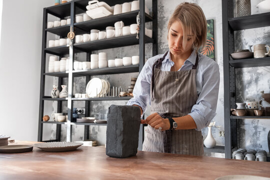 Female potter cutting clay