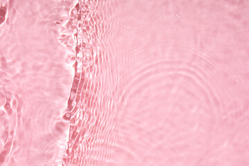 Pink liquid colored clear water surface texture with splashes bubbles with copy space. Water waves...