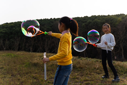 Two kids playing soap bubble