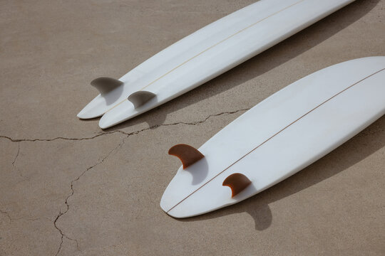 two white surf boards on concrete
