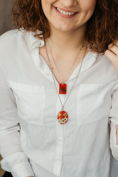 Curly haired woman wearing floral epoxy necklace  
