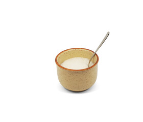 Ceramic sugar bowl with white sugar and metal spoon. Highlighted on a white background.