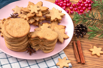 Obraz na płótnie Canvas full plate of homemade freshly made gingerbread cookies on wooden background. Christmas tree decorations on the table. Classic traditional Christmas cookies with spices, cinnamon, cumin and ginger