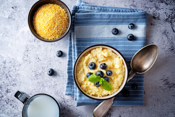 Corn porridge with fresh blueberries in a bowl