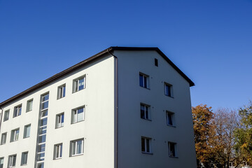 Close up of white house with clear blue sky background with an autumn foliage on the back. Bottom up view. Pelgulinna, Tallinn, Estonia, Europe. September 2021
