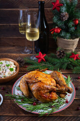 Baked whole chicken or turkey for Christmas. New Year's table with decoration, homemade roasted chicken, wine and salad
