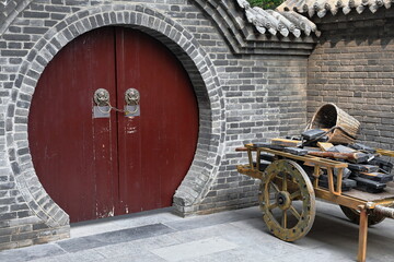 Maroon painted-round door-wooden cart-building materials. City Wall's Yongning South Gate-Xi'an-China-1589