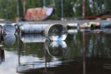 Graffiti bottles in puddle 1