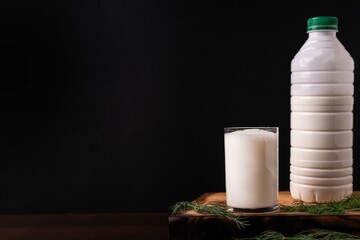 Turkish or Azerbaijan traditional Drink Ayran or Kefir in a glass on a wooden table on a black...