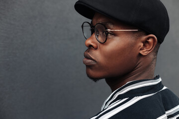 close-up portrait of an african american man against a background of a black brick wall, a black man posing