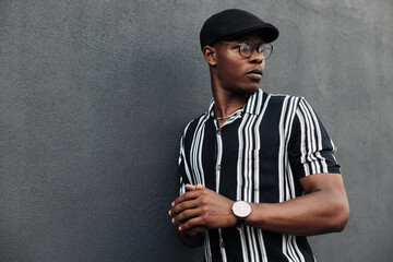 African American man in a shirt in a line, against a background of a black brick wall, stylish guy, close-up