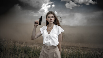 An aggressive warrior girl in stylish clothes. The girl with the gun. A dramatic cinematic scene with weapons. A young girl with a gun in her hands
