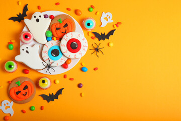 Halloween sweets on colored background close up top view with place for text