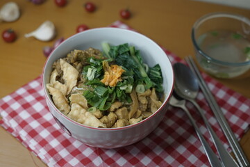 Mie Ayam or chicken noodle, Indonesian cuisine. Yellow wheat noodle topped with chicken meat, mushroom, bok choy. Served with fried wonton, scallion and fried shallot.