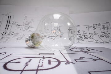 Closeup of light bulb with cables, fuses, diagrams