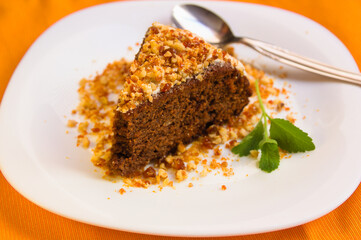Chocolate cake with almonds and caramel next to a stevia branch