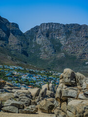 Shot of Camps Bay through the beach rocks in the foothill of Twelve Apostles mountain