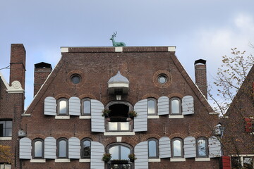 Amsterdam Brouwersgracht Canal Historic Brick Building Facade with Grey Wooden Shutters and Green Deer Sculpture on Top, Netherlands