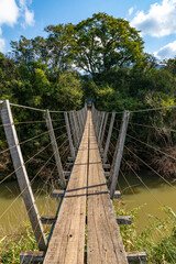 Wood and iron bridge over Cadeia river with forest around