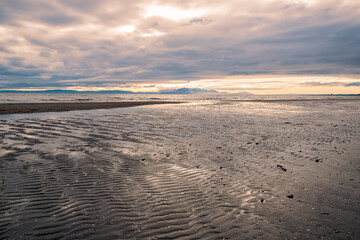 Sandy beach with dramatic clouds at sunset seen from the beach in Irvine, Scotland.