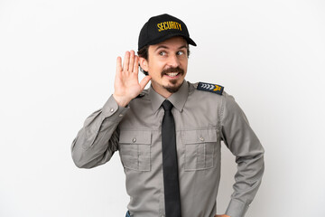 Young caucasian security man isolated on white background listening to something by putting hand on the ear