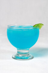 shot of cozumel, margarita, tequila drink with lemon in the glass on the table, horizontal image with blurred background