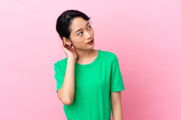 Young Vietnamese woman isolated on pink background thinking an idea