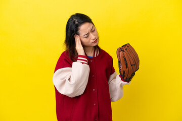 Young Vietnamese player woman with baseball glove isolated on yellow background with headache