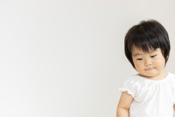 落ち込んでいる赤ちゃんのイメージ（1歳2か月、日本人、女の子）
