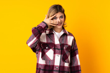Young Russian woman isolated on yellow background covering eyes by hands and smiling