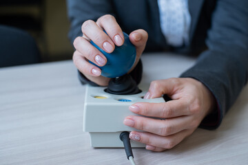 Woman with cerebral palsy works on a specialized computer mouse.